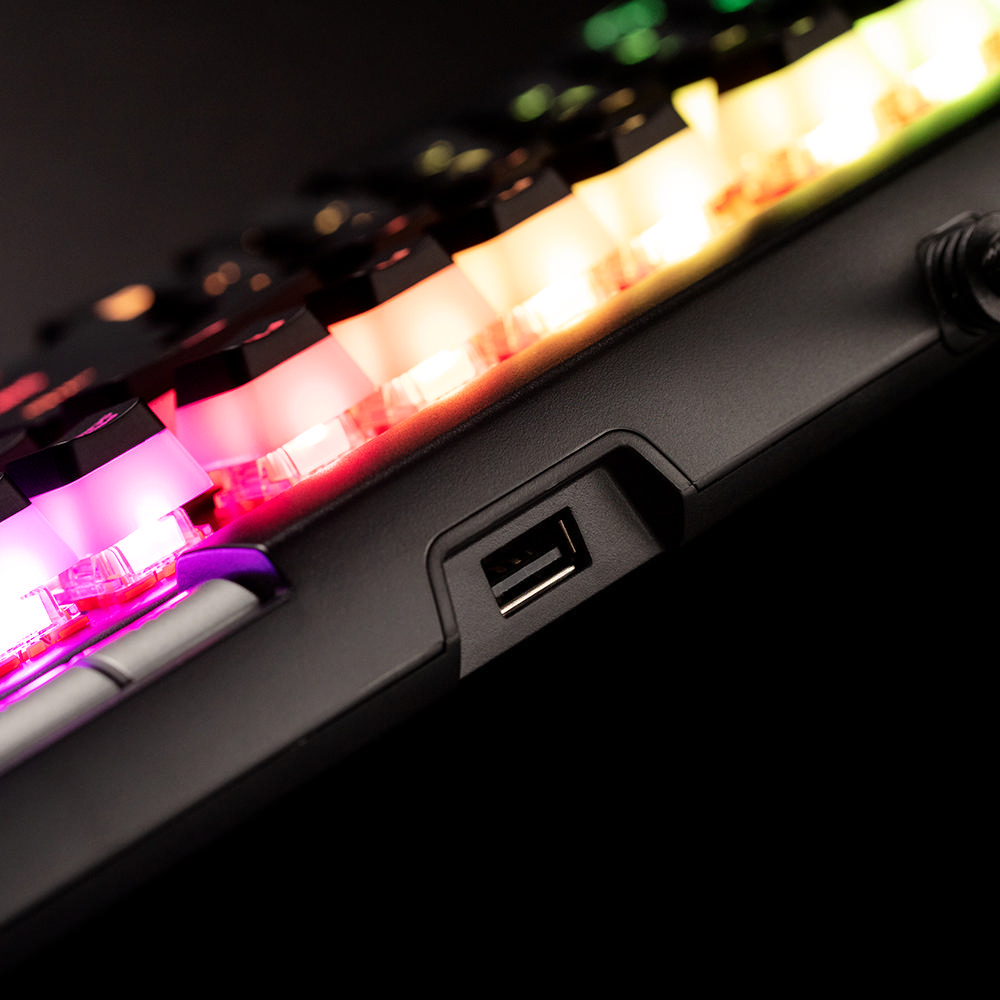 Nahaufnahme einer schwarzen Tastatur mit farbigen LED-Lichtern. Ein USB-Anschluss ist seitlich sichtbar.