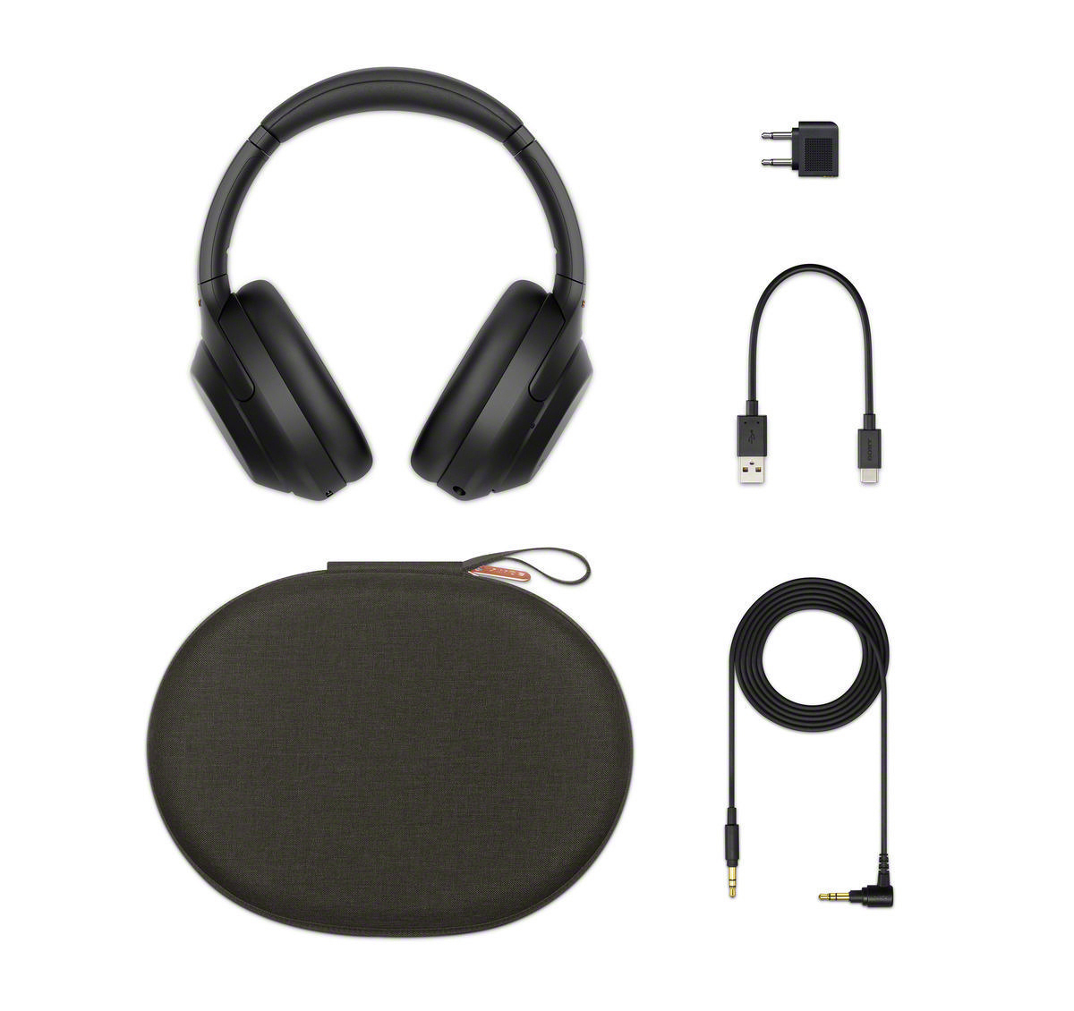 Schwarze Sony WH-1000XM4 Kopfhörer mit Zubehör: Ladegerät, Kabel und Etui, weißer Hintergrund.