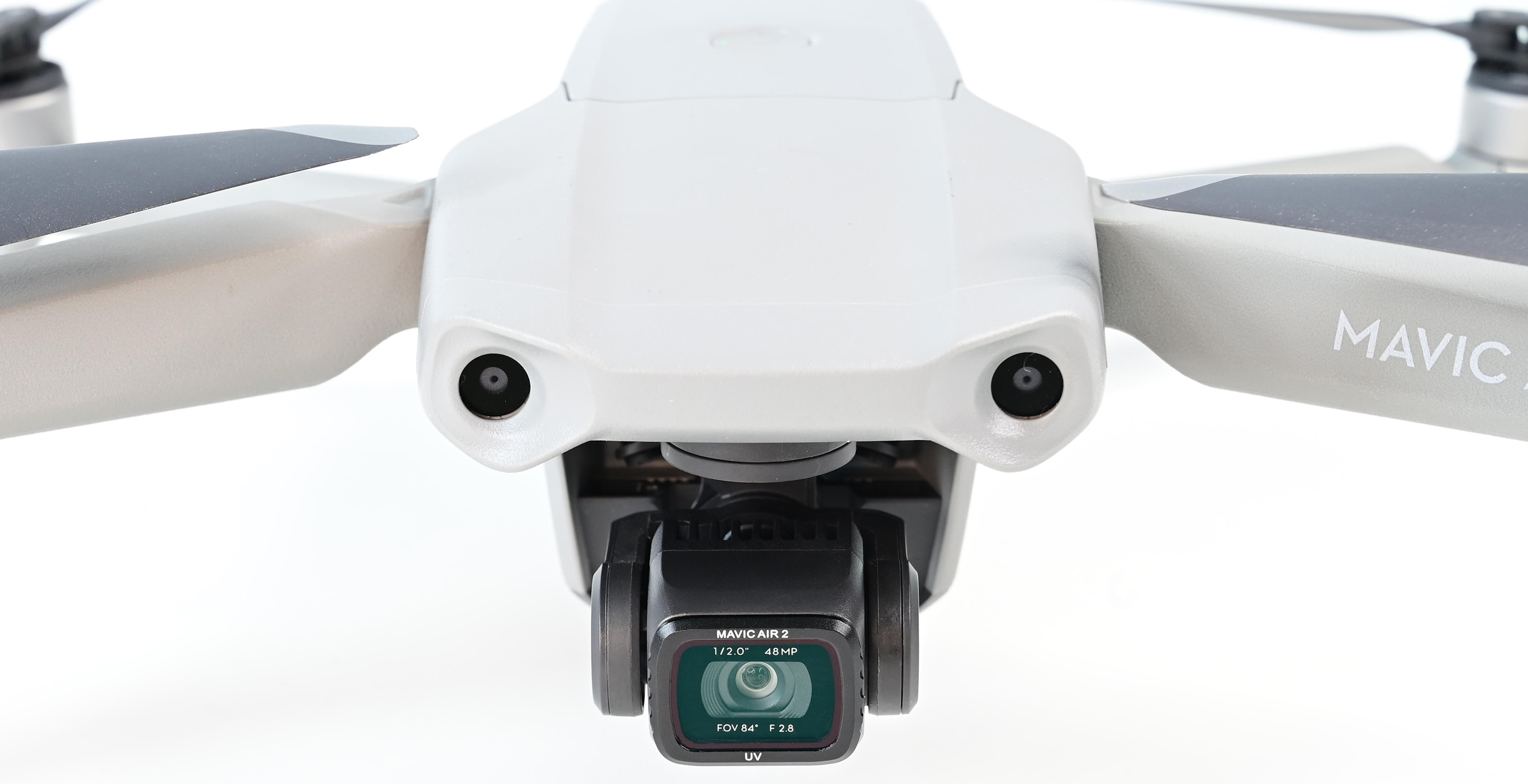 White drone with camera. The camera has a green lens and the text Mavic Air 2.