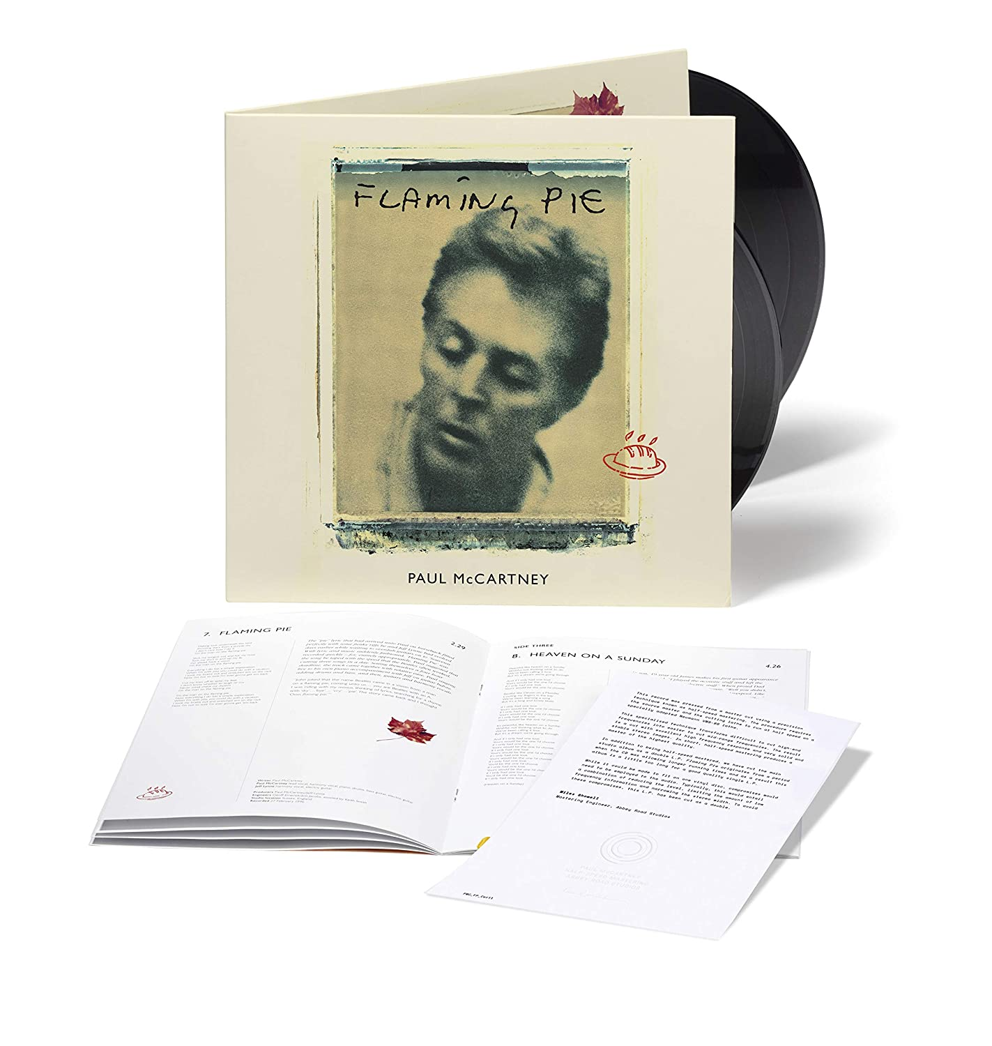 'Flaming Pie' albumborítója Paul McCartney fotójával és szövegével. Egy bakelit lemez látható.
