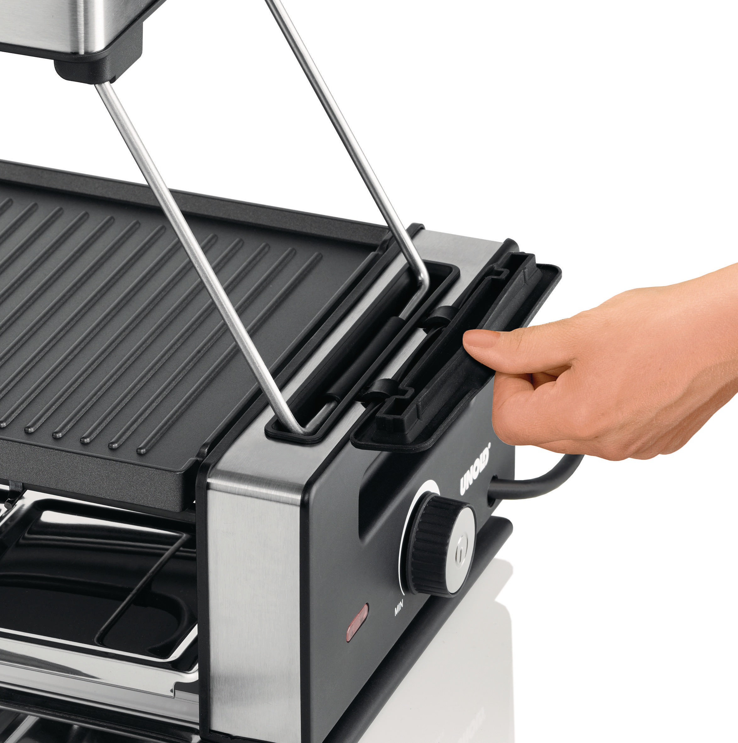 Hand bedient einen Raclette-Grill, der obere Teil ist angehoben.