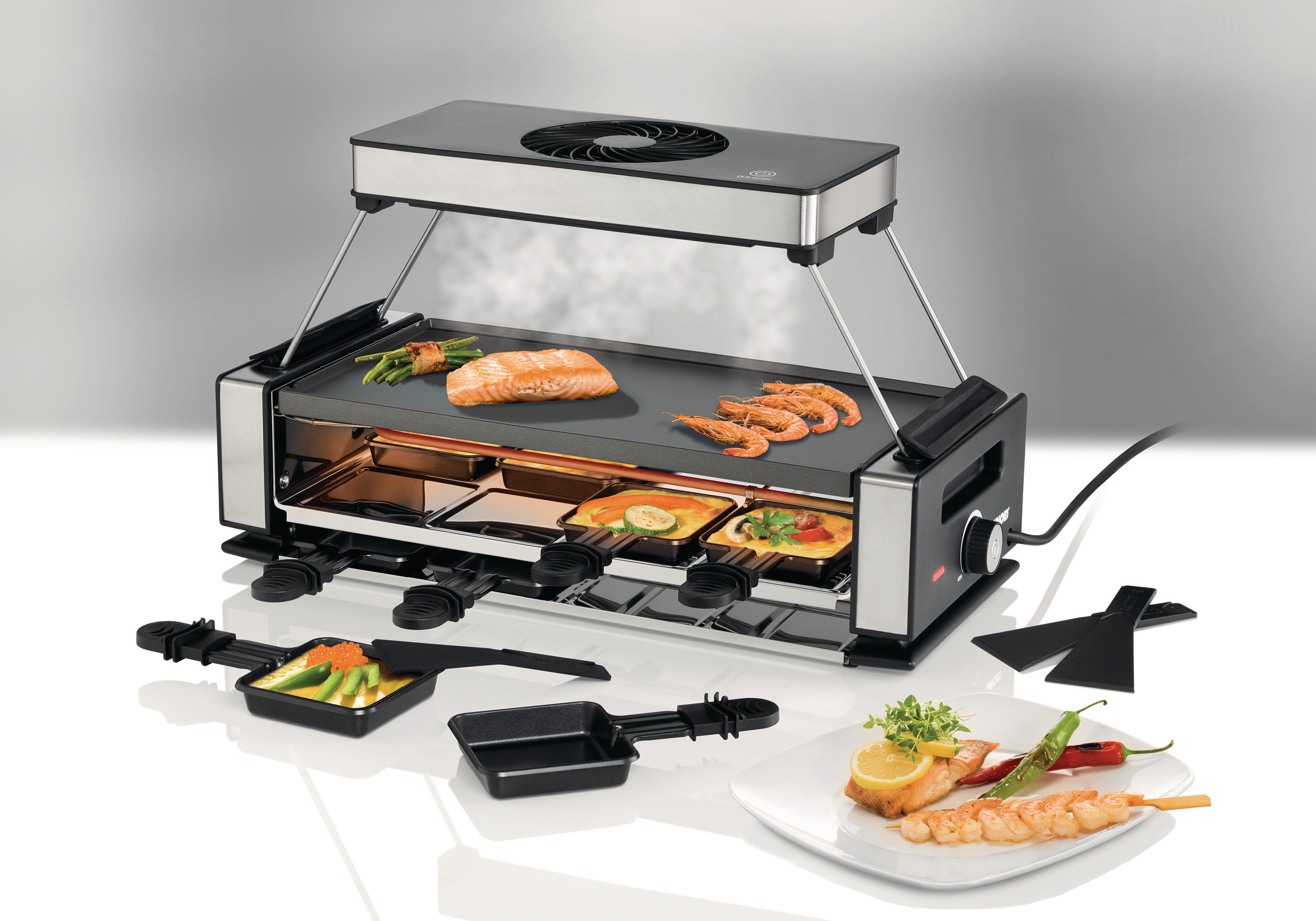 Raclette-Grill mit Essen. Enthält Käse, Garnelen und Gemüse mit Ventilator.