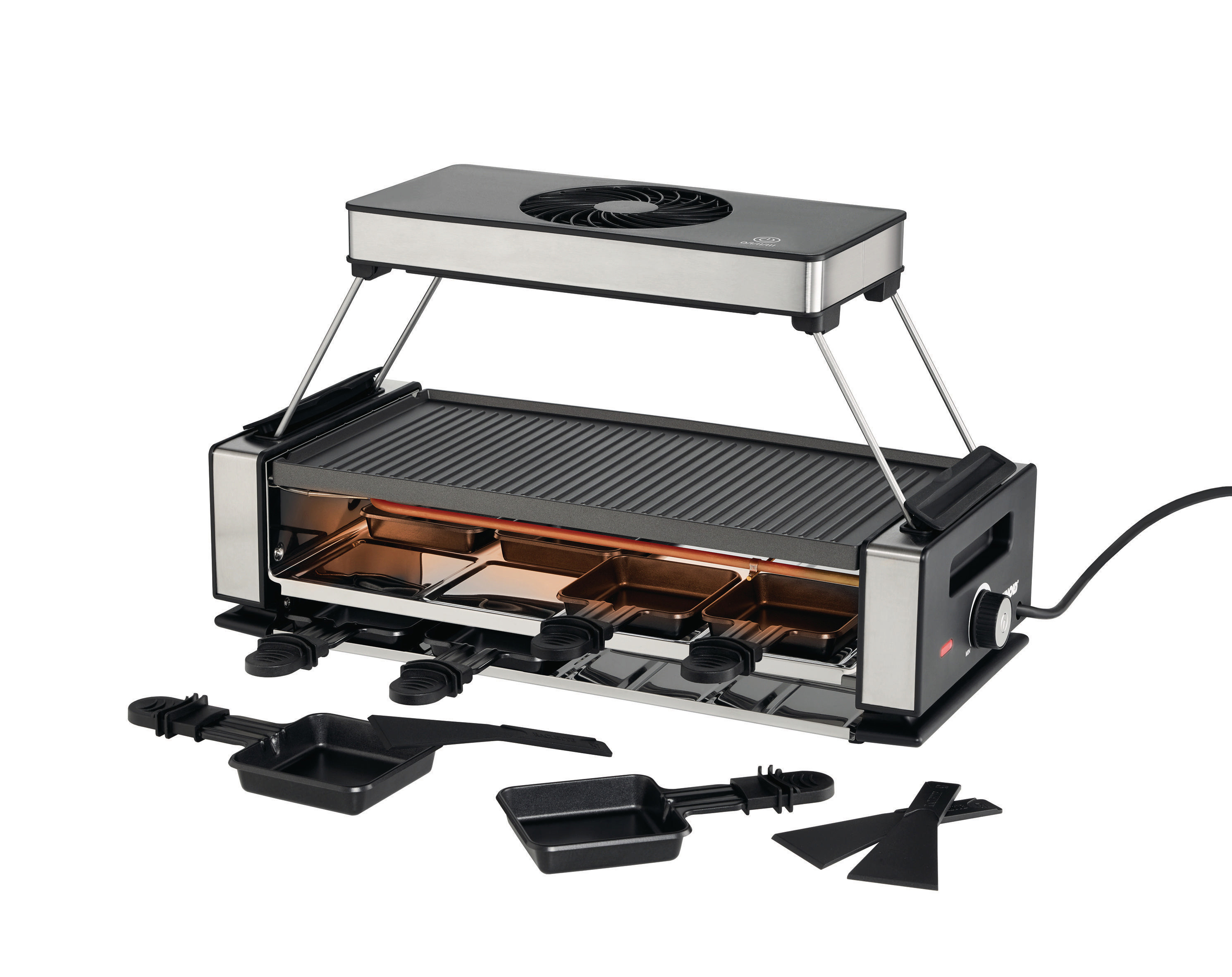 Ein Raclette-Grill mit schwarzer Oberseite, vier Käsepfännchen und zwei Spateln. Er steht auf einer weißen Oberfläche.