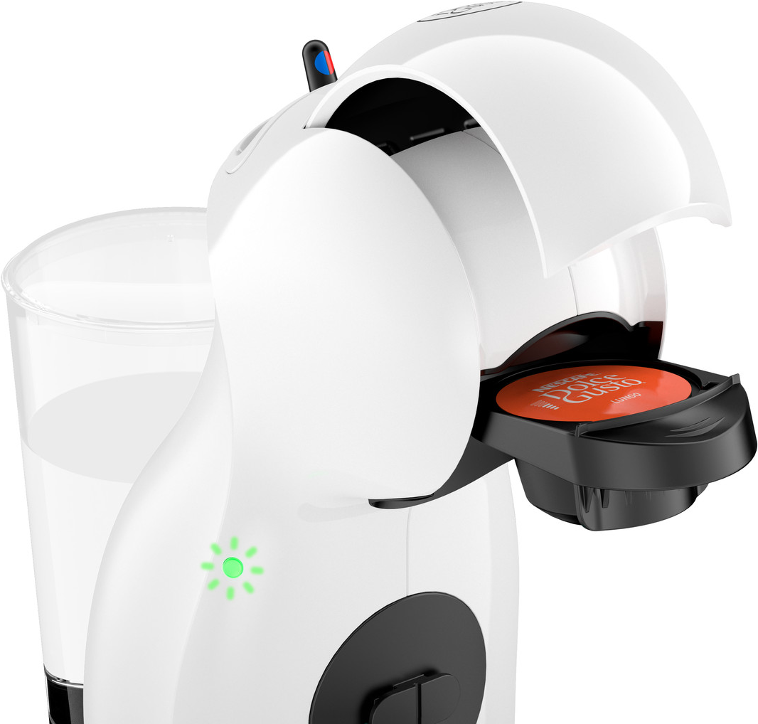 Macchina da caffè Dolce Gusto bianca con una cialda di caffè rossa inserita. Bicchiere d'acqua accanto.