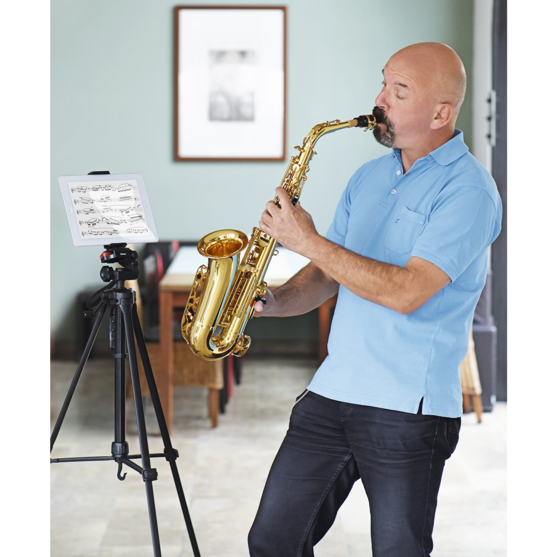 Ein Mann spielt ein goldenes Saxophon, Noten auf einem Ständer. Innenszene.