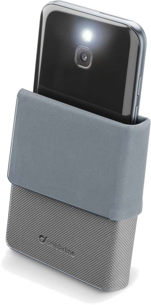 Un téléphone dans un étui gris avec une lampe de poche allumée. L'étui est posé sur une base de chargement en forme de maillage.