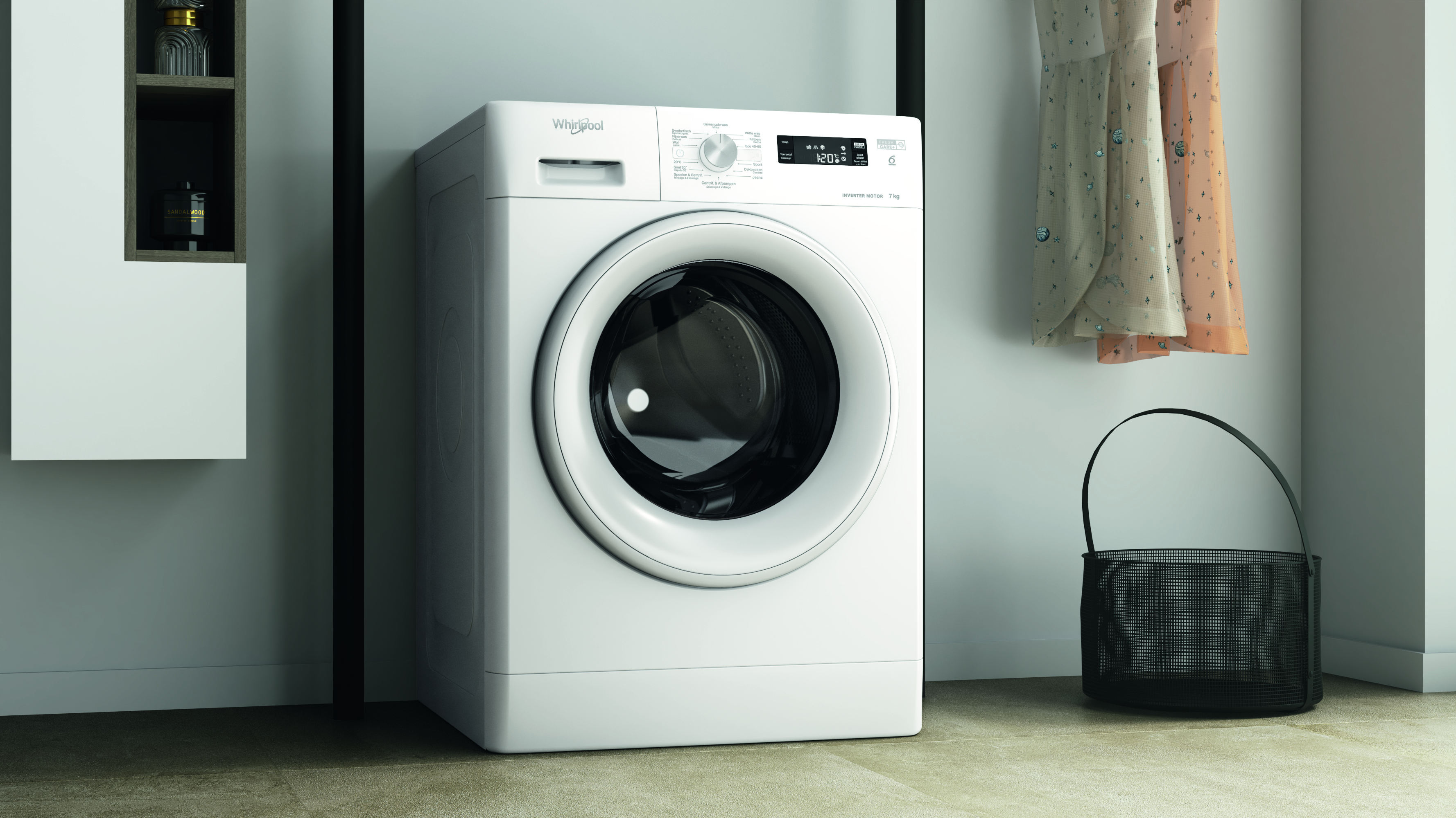 Een witte Whirlpool wasmachine staat naast een zwarte mand en hangende jurken. Links een plank met flessen.