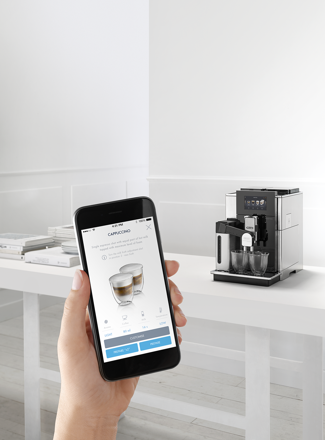 Person using a smartphone to control a coffee machine.