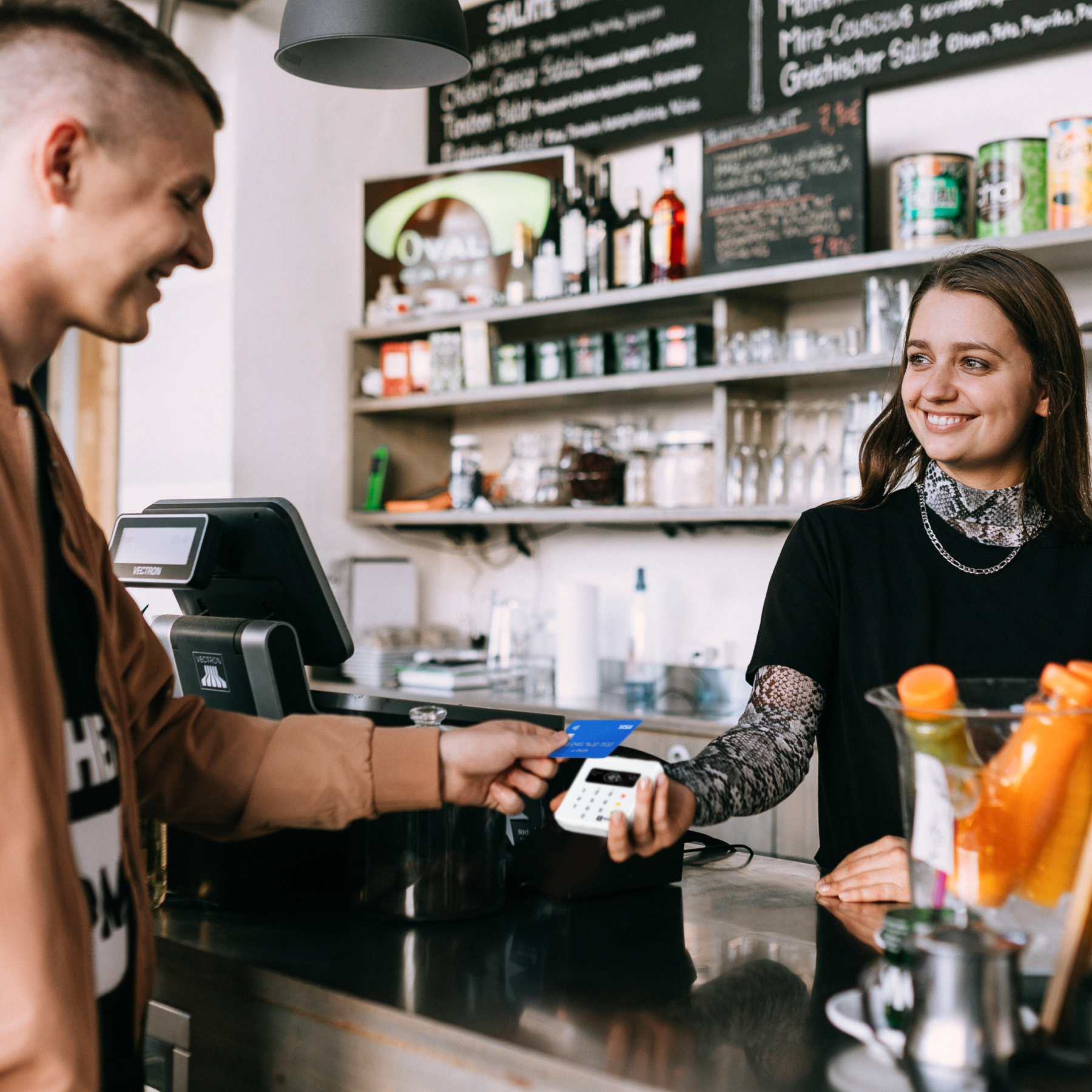 Kunde gibt Kassierer in einem Café eine Kreditkarte.