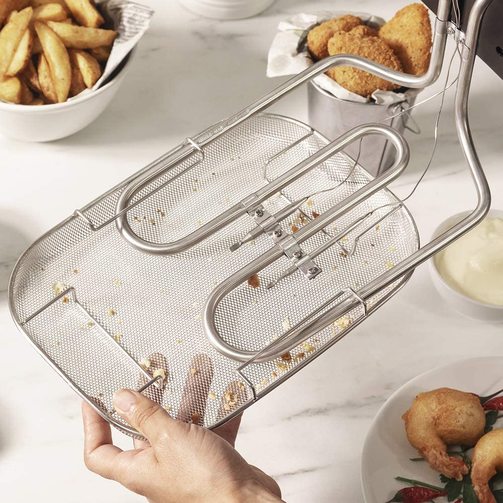 Mano sosteniendo una cesta de malla metálica con alimentos fritos.