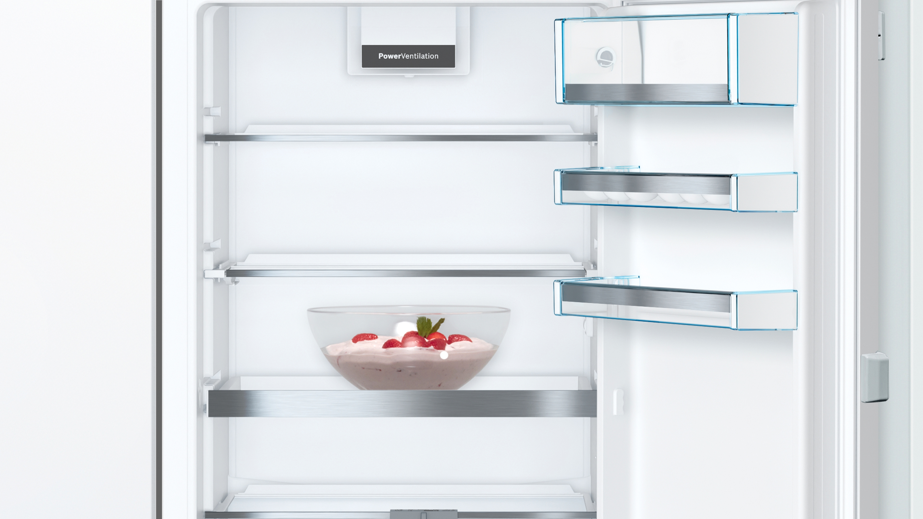 Offener Kühlschrank mit Einlegeböden. Innen eine Schüssel mit Dessert und Erdbeeren. Oben rechts, Regale mit Eiern.