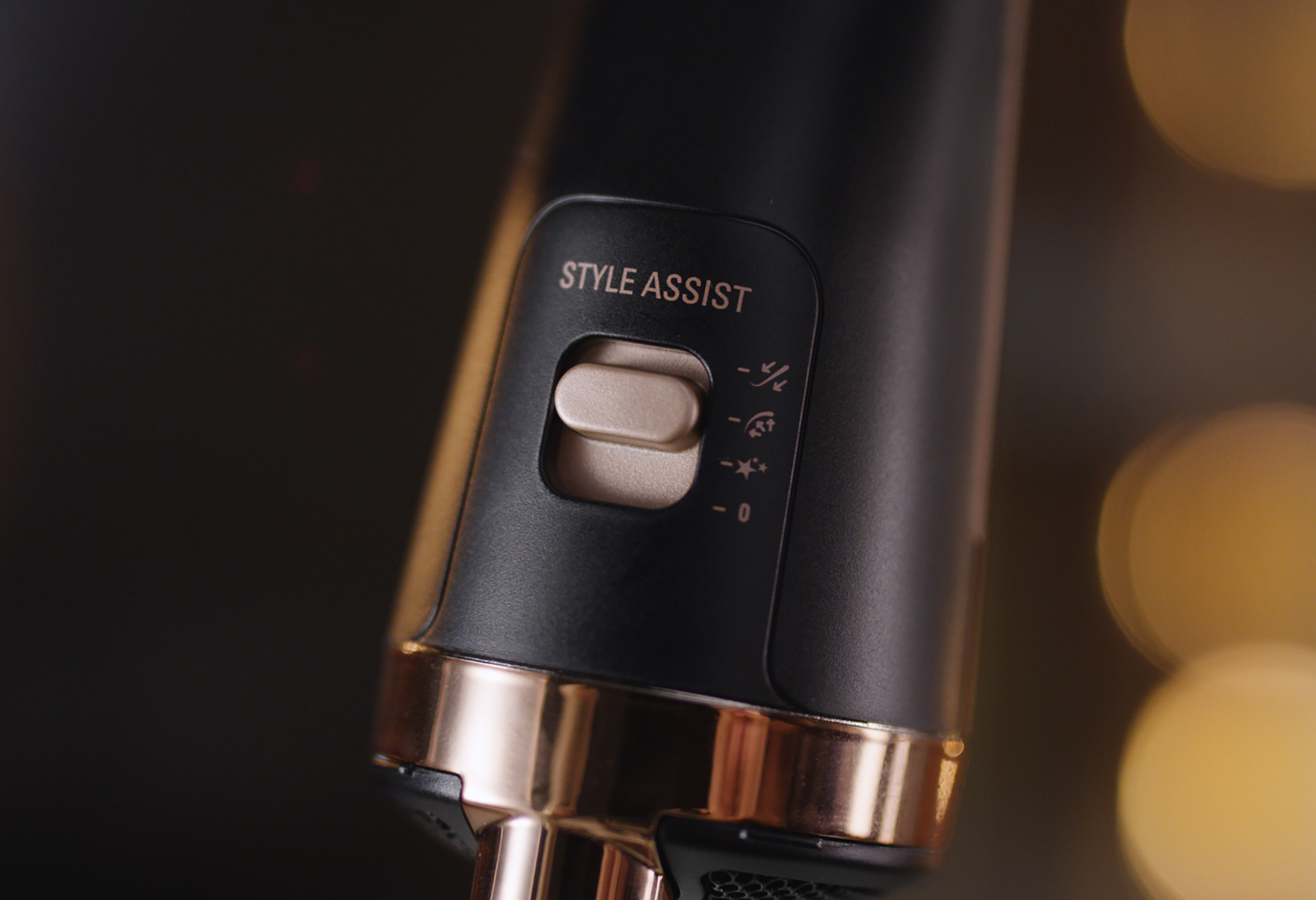 Nahaufnahme eines schwarz-goldenen Haarstyling-Tools mit der Taste 'STYLE ASSIST'.