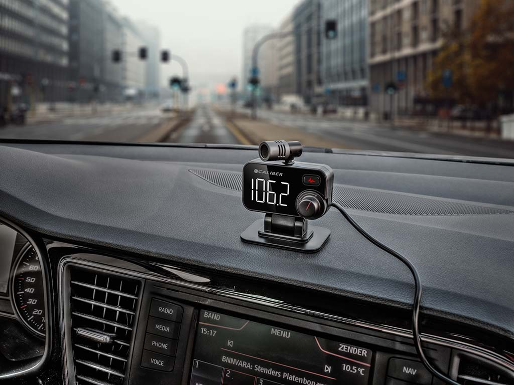 Armaturenbrett eines Autos mit Digitalanzeige, die 106,2 anzeigt. Ein Mikrofon ist am Armaturenbrett befestigt.