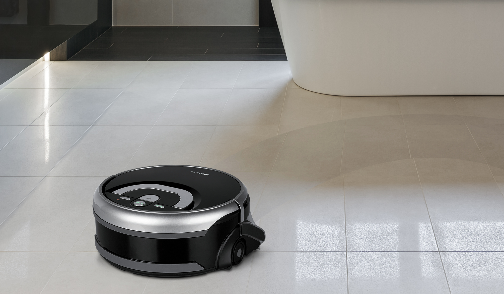 Ein schwarzer und silberner Roboter-Staubsauger auf einem Fliesenboden, mit Badewanne im Hintergrund.
