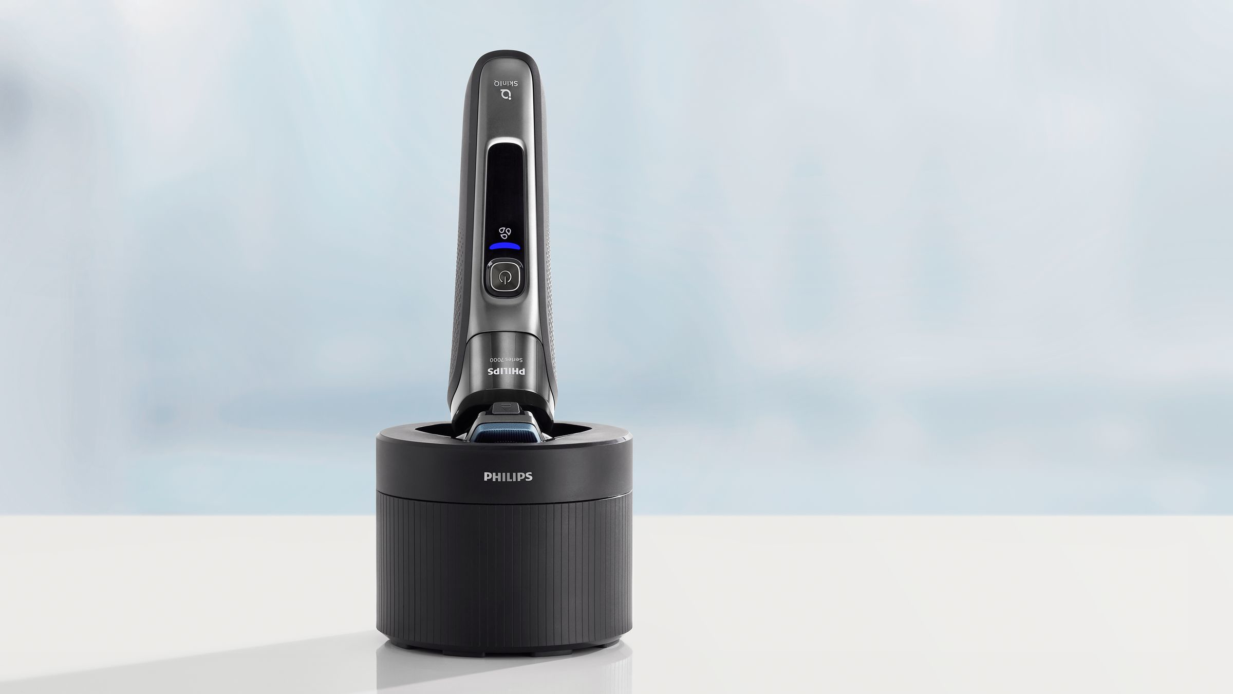 Ein Philips Elektrorasierer auf seinem Ständer. Der Rasierer ist schwarz und silber. Der Ständer ist schwarz.