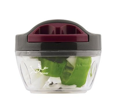 Un picador de alimentos transparente con verduras picadas dentro, sobre fondo blanco.