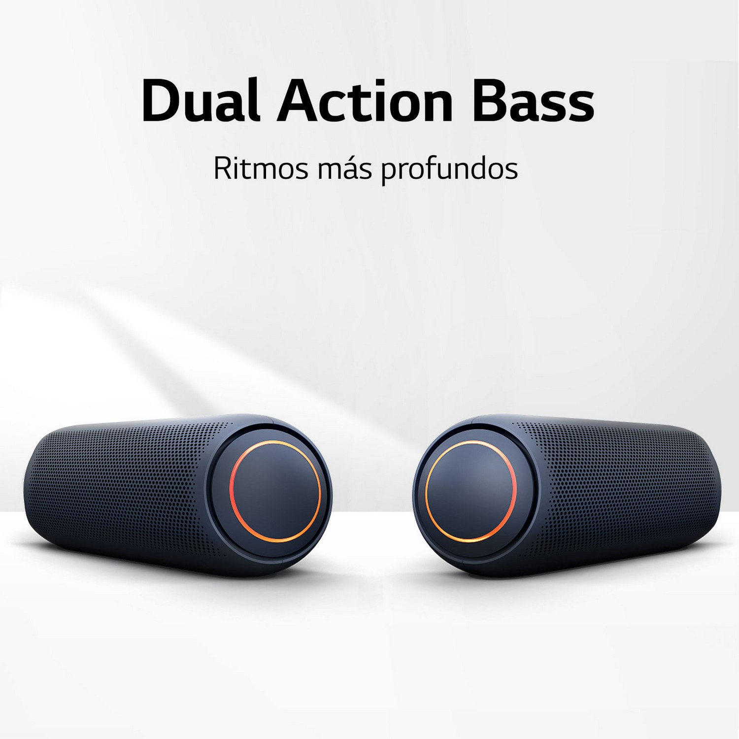 Par de altavoces negros con detalles naranjas sobre una superficie blanca.