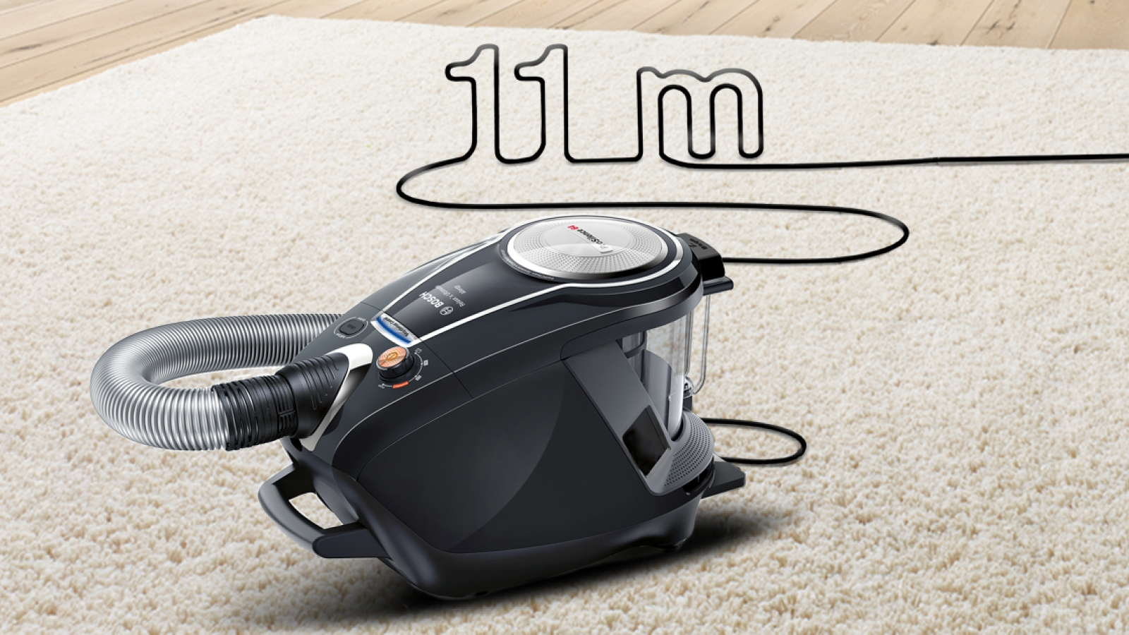 Schwarzer Staubsauger auf weißem Teppich, mit sichtbarem 11m Kabel. Der Teppich ist weiß.