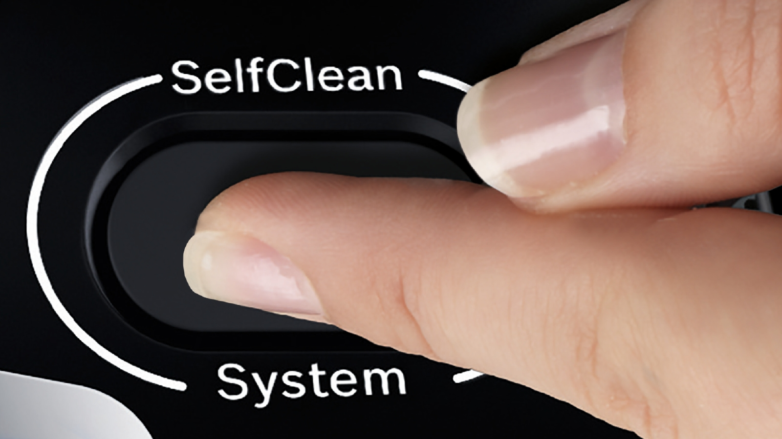 Ein Finger drückt eine schwarze Taste mit der Aufschrift 'SelfClean' auf einem schwarzen Gerät.