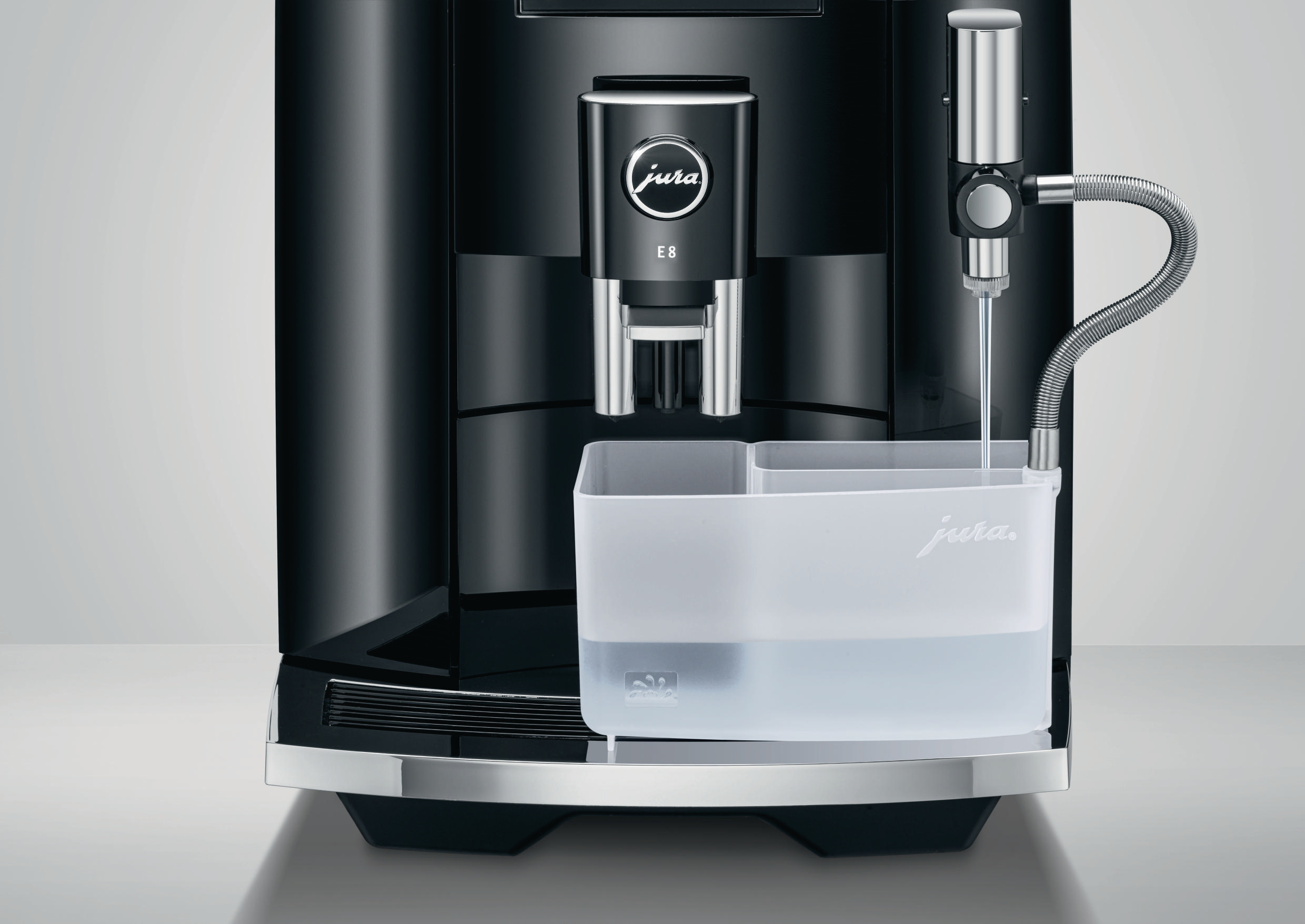 Schwarze Kaffeemaschine mit Wasserbehälter vorne und einem 'Jura'-Logo.