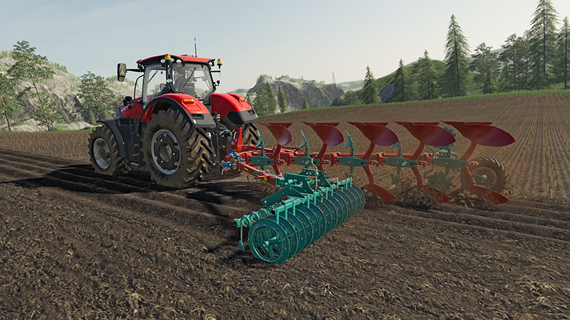 Een rode tractor die een veld ploegt met een blauwe en rode ploeg in een landelijk landschap.