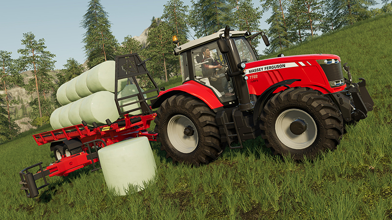 Rode Massey Ferguson tractor met een aanhanger met hooibalen op een grasheuvel.