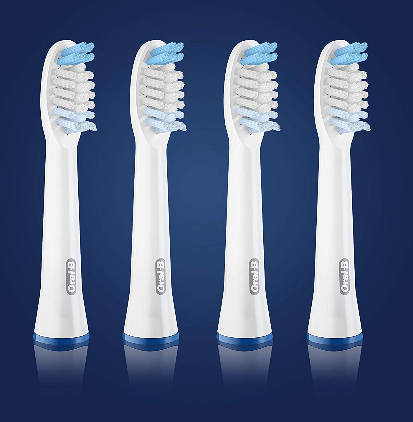 Quattro testine bianche per spazzolino con setole blu. Disposte su uno sfondo blu scuro.