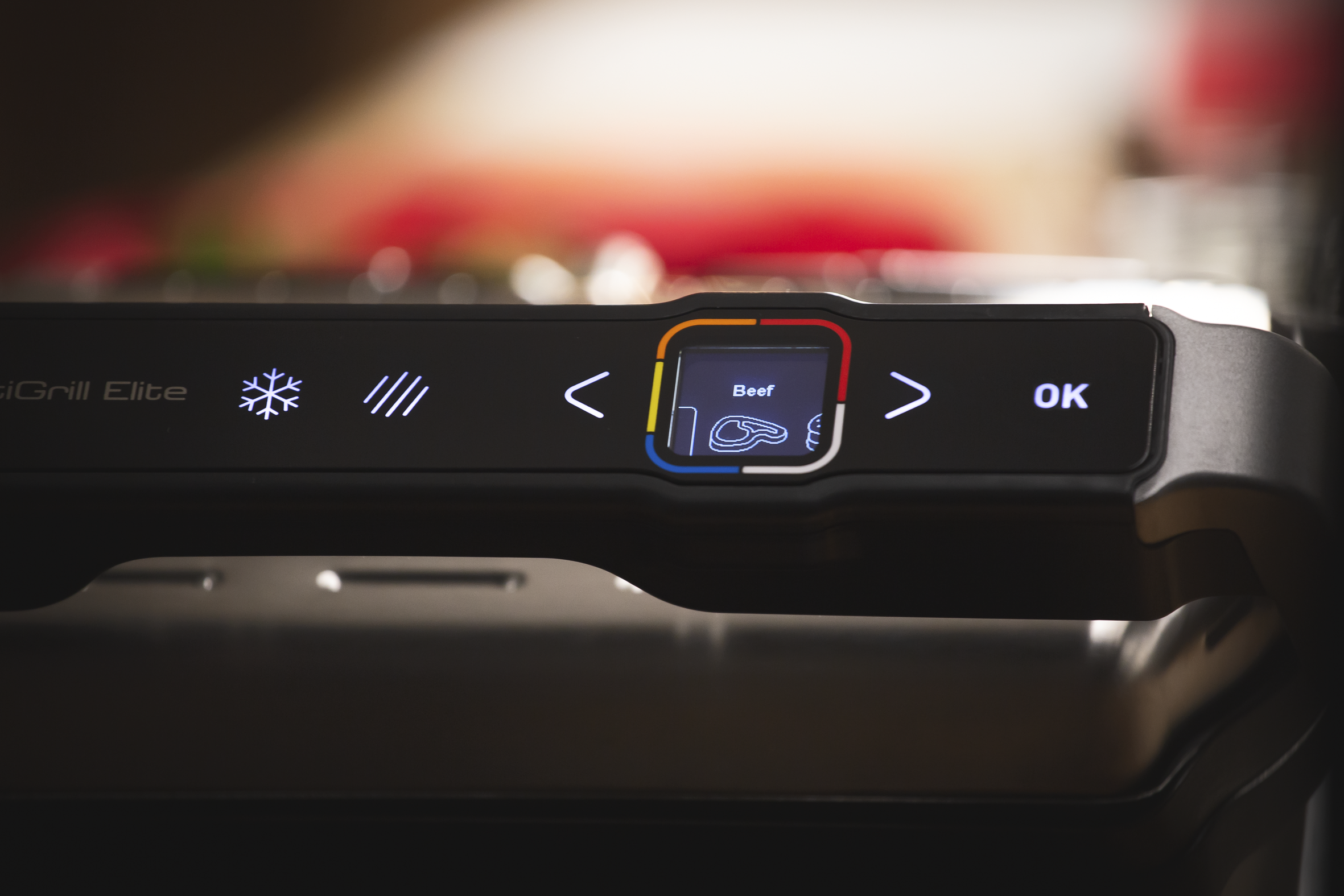 Close-up of a grill control panel showing a beef setting, arrows, and an OK button.
