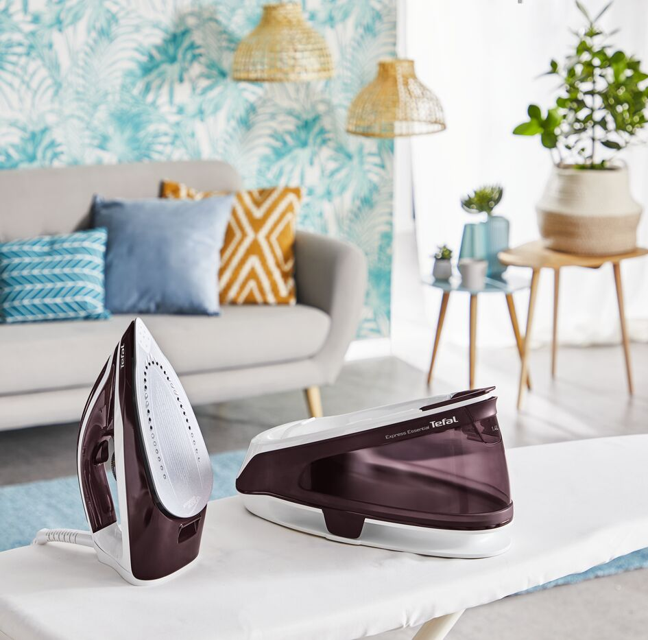 Ironing board with iron, ironing station in living room setting.