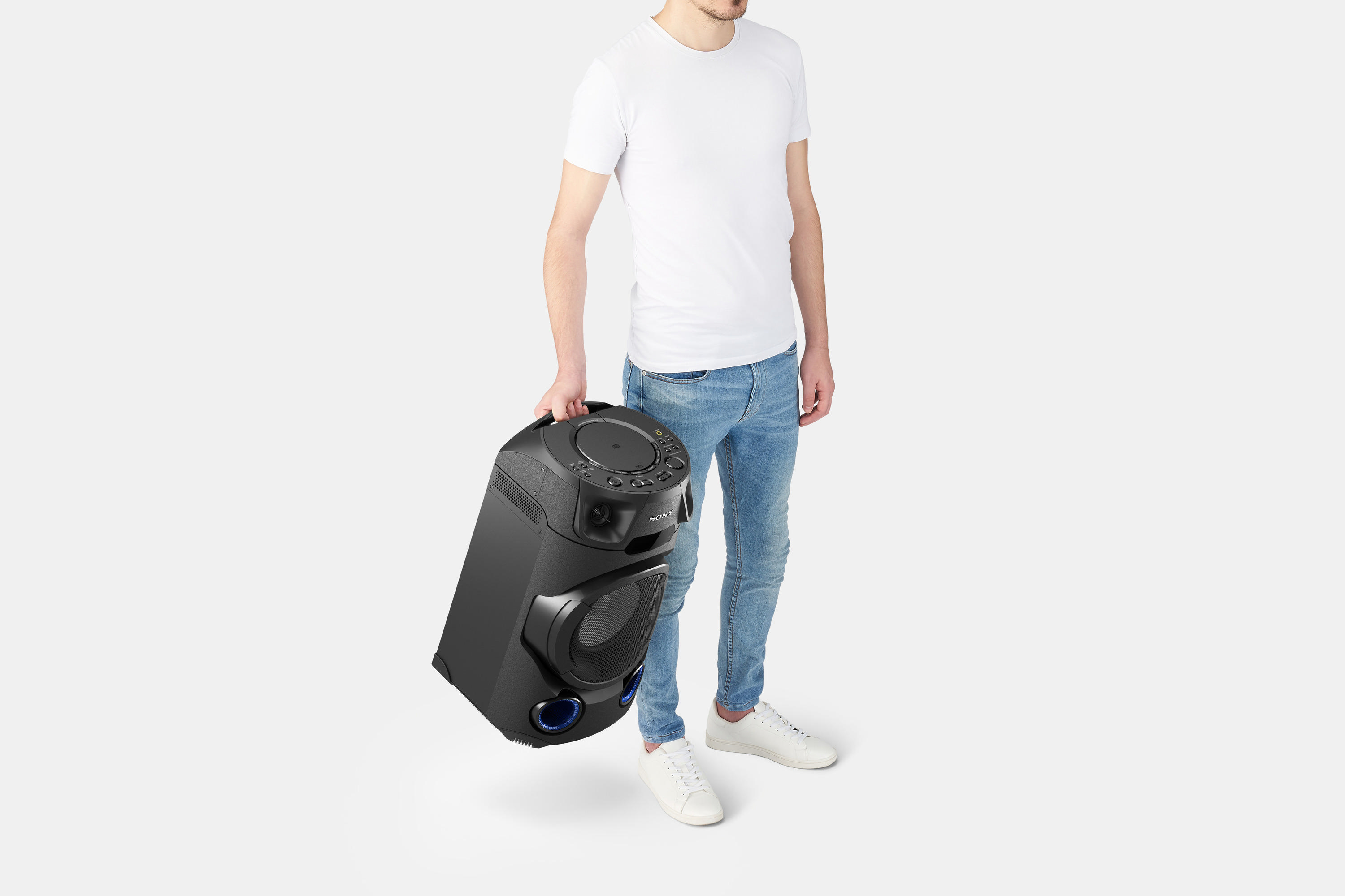 Ein Mann hält einen schwarzen Lautsprecher. Weißer Hintergrund.