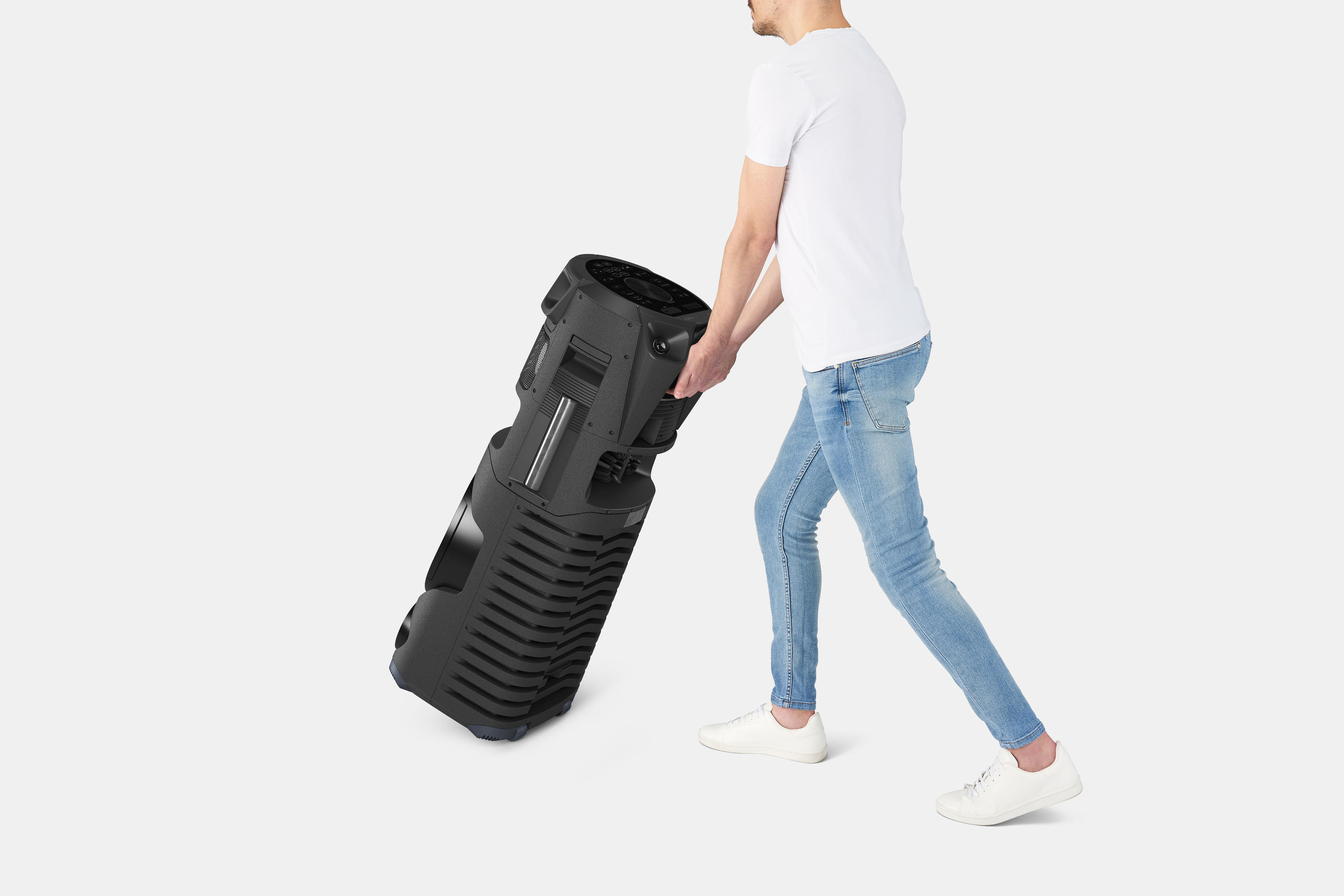 Ein Mann trägt einen großen schwarzen Lautsprecher.