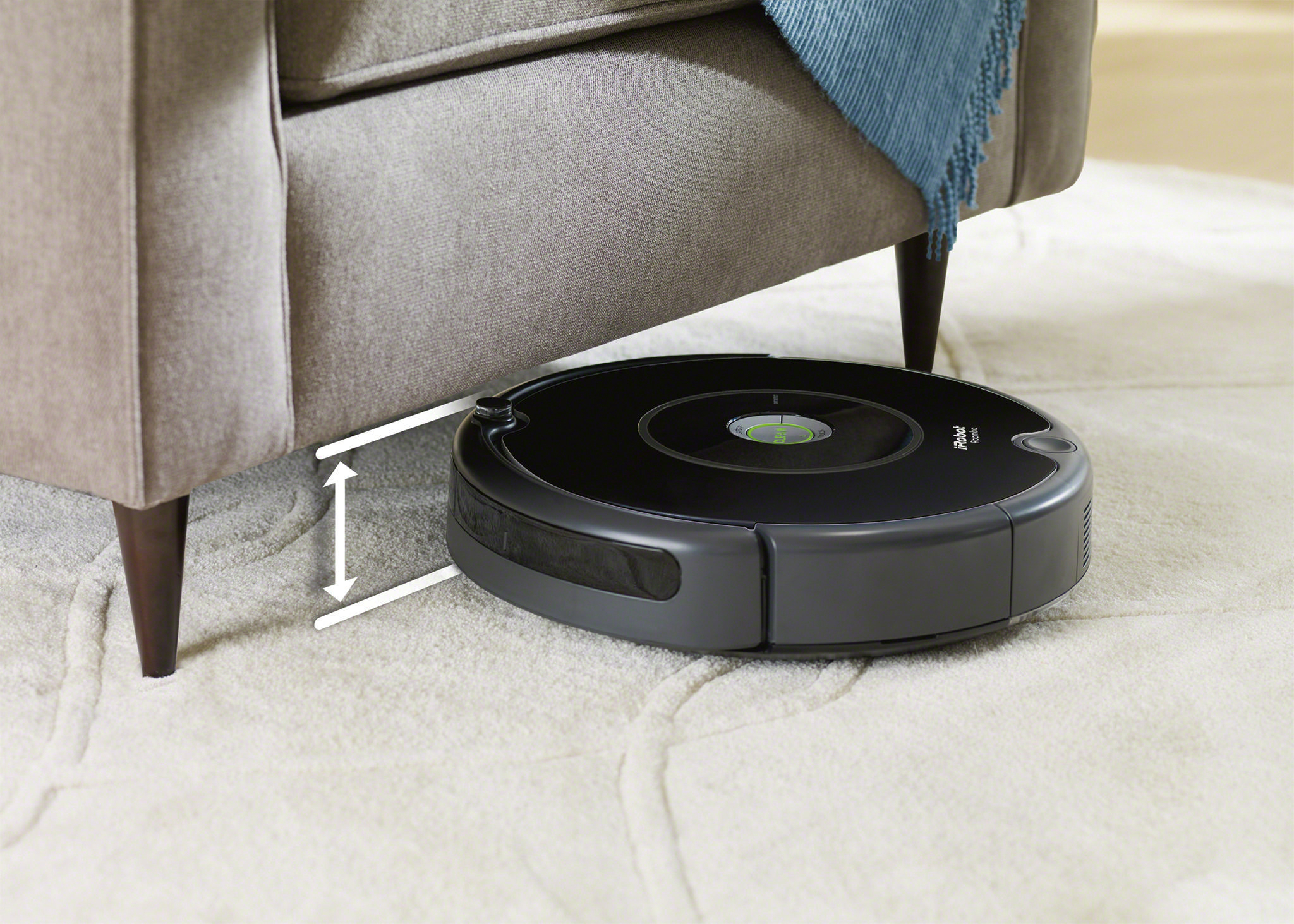 Roboter-Staubsauger unter einer Couch, zeigt niedriges Profil und Reinigungsfähigkeit.