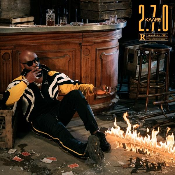 Albumhoes: een man in het zwart, zittend, met vuur en een bar op de achtergrond.