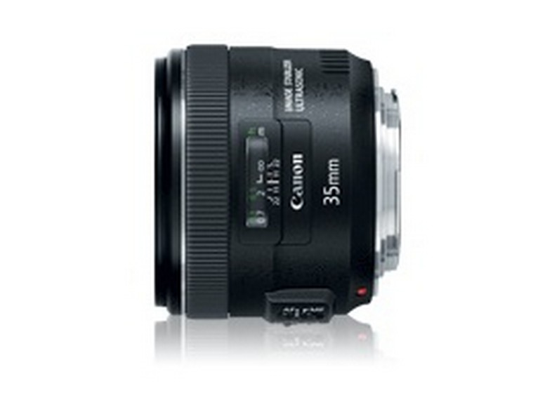 Una lente Canon de 35 mm negra. Es cilíndrica con anillos y marcas para enfoque y zoom.