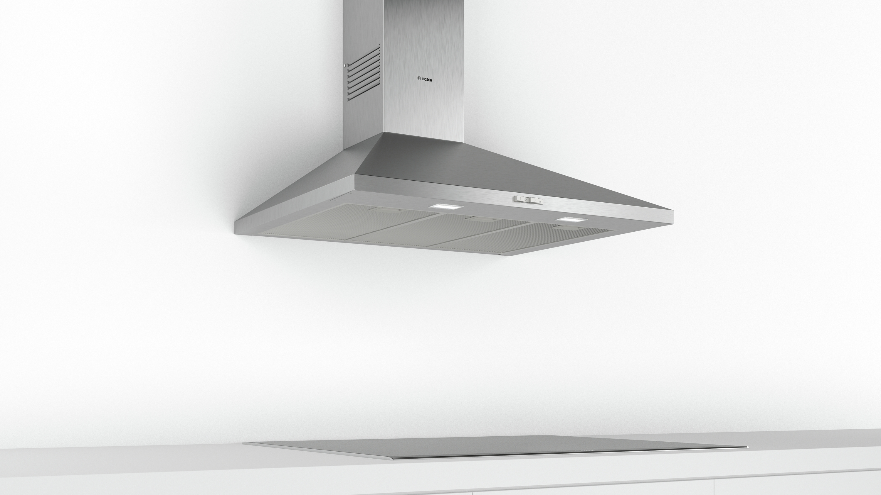 A stainless steel range hood over a cooktop.