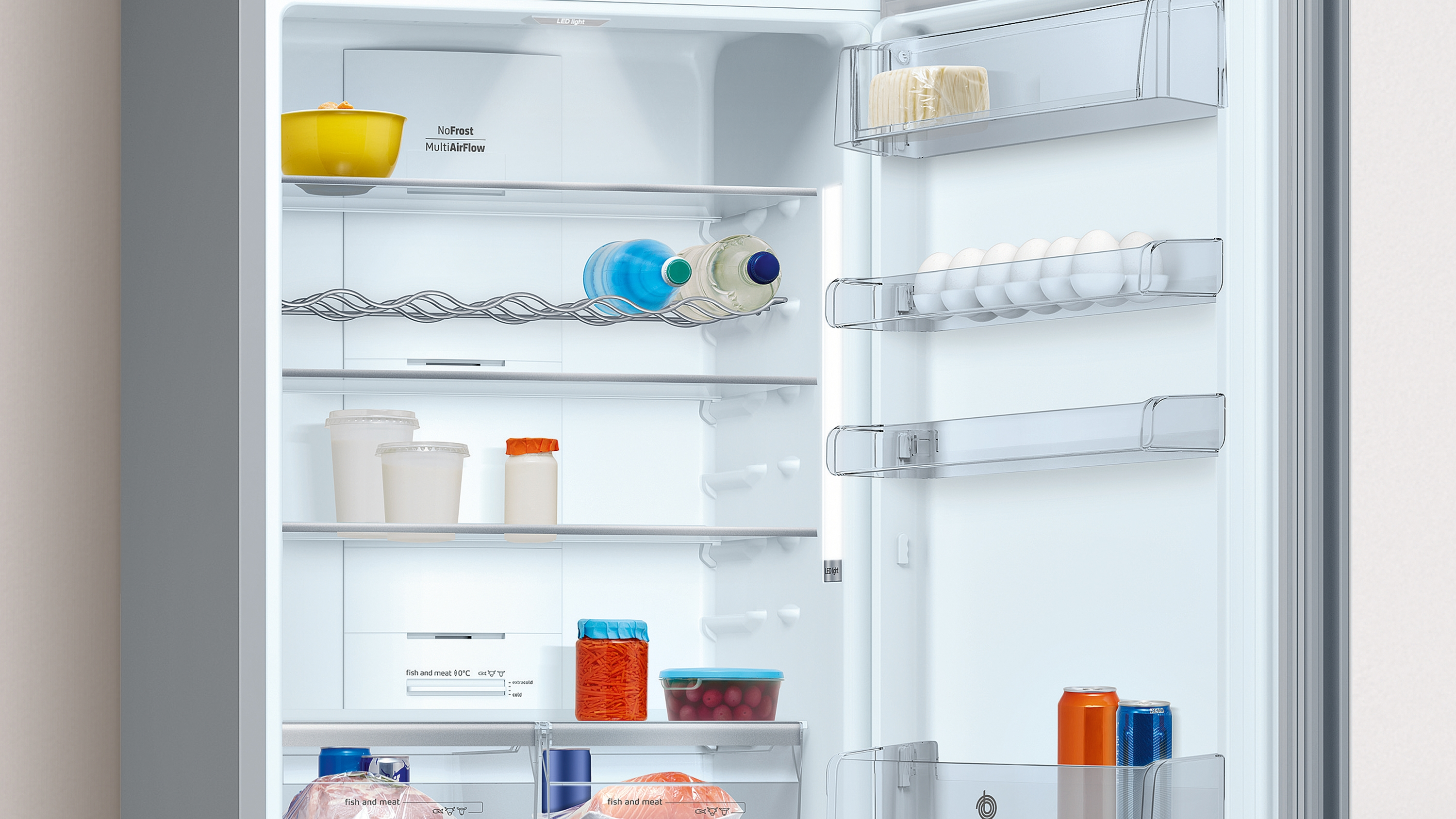 Interior de refrigerador con estantes que contienen alimentos, incluyendo botellas, huevos y recipientes.