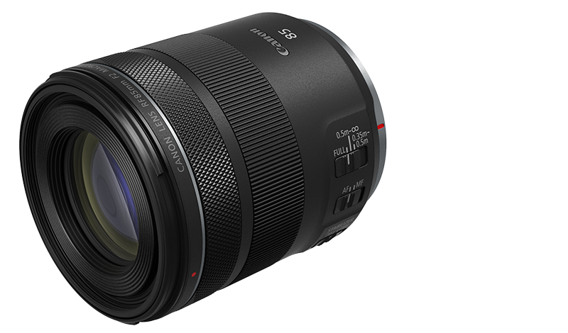 Egy Canon RF 85mm F2 MACRO IS STM objektív, fekete, feketén izolálva, címkékkel.