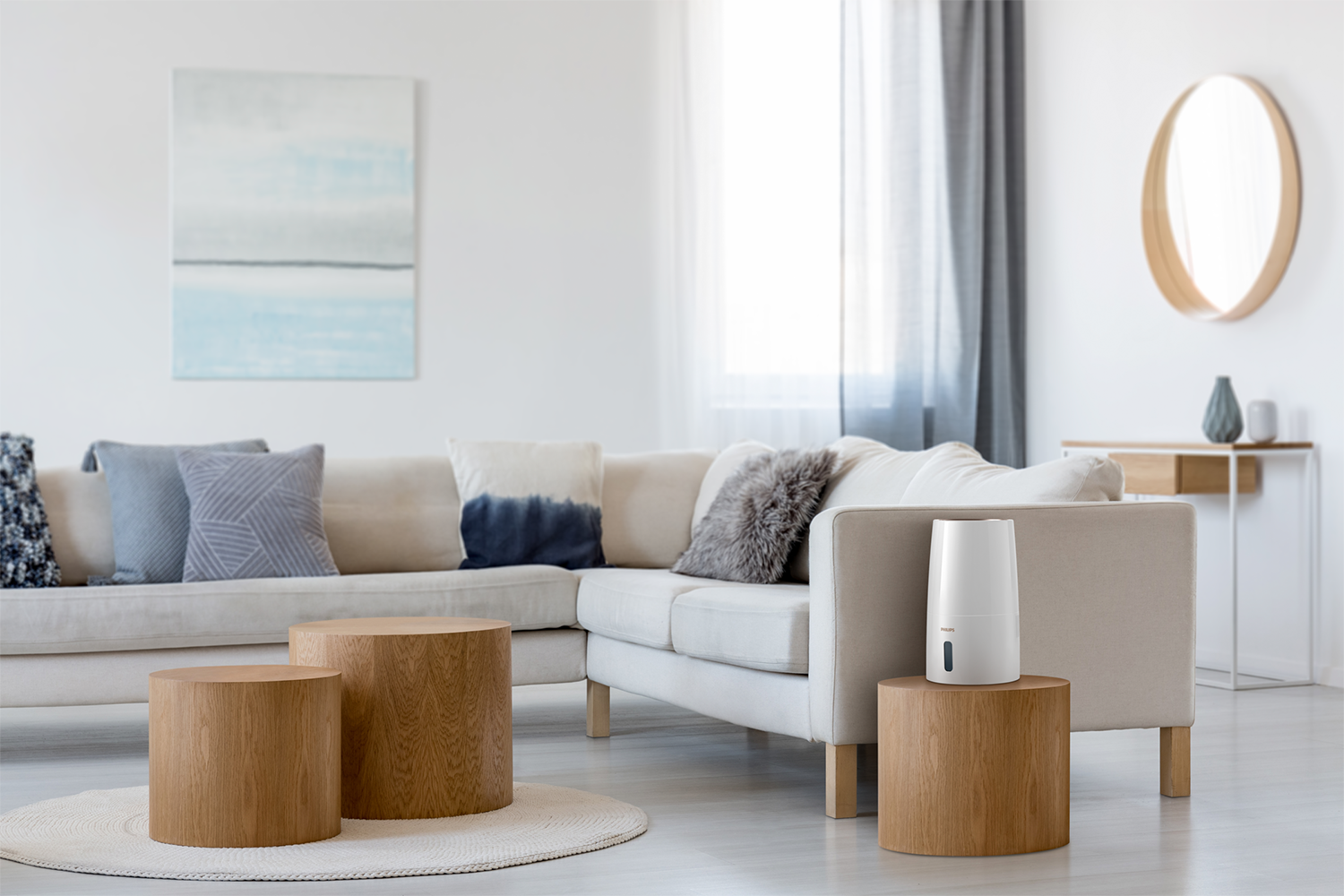 A modern living room with a white sofa, wooden tables, and a humidifier on a table. Bright and airy.