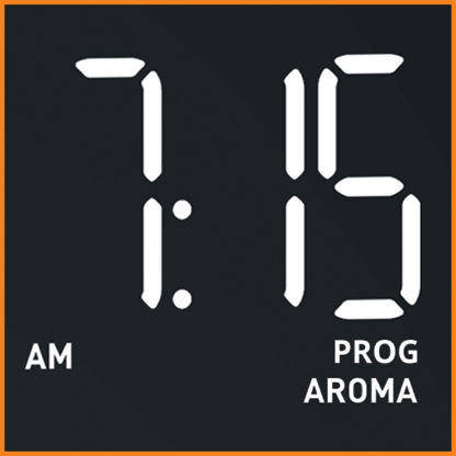 Digitaluhr mit der Anzeige 7:15 Uhr morgens und dem Wort 'PROG AROMA' darunter.