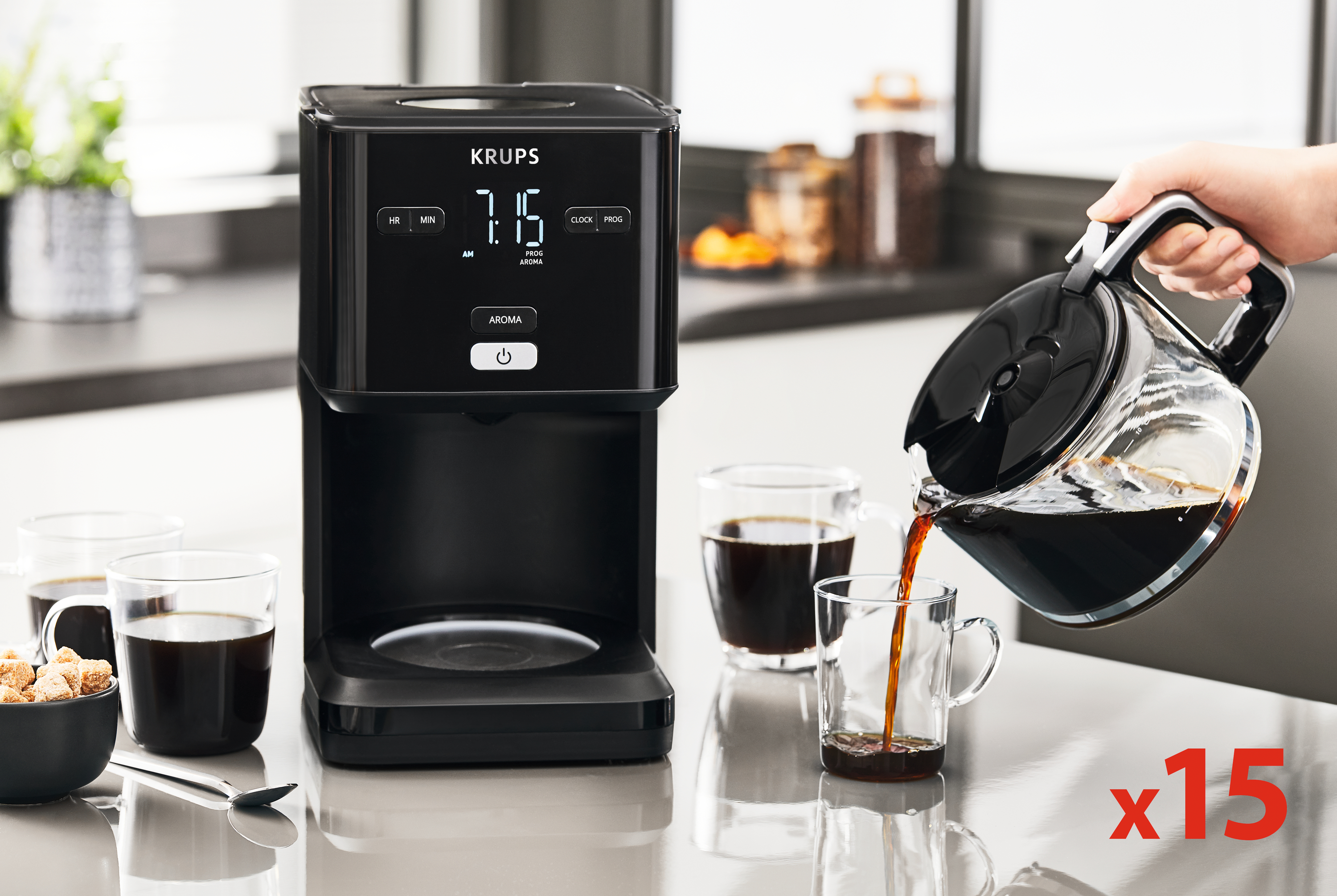 Schwarzer Krups-Kaffeeautomat, gießt Kaffee in ein Glas. Brauner Zucker, Tassen. Küchenszene, x15.