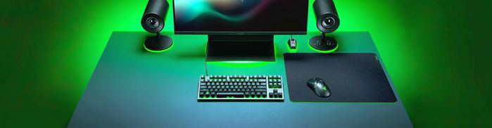 Configuration de jeu avec un bureau, des haut-parleurs, un moniteur, un clavier, une souris et un tapis de souris.