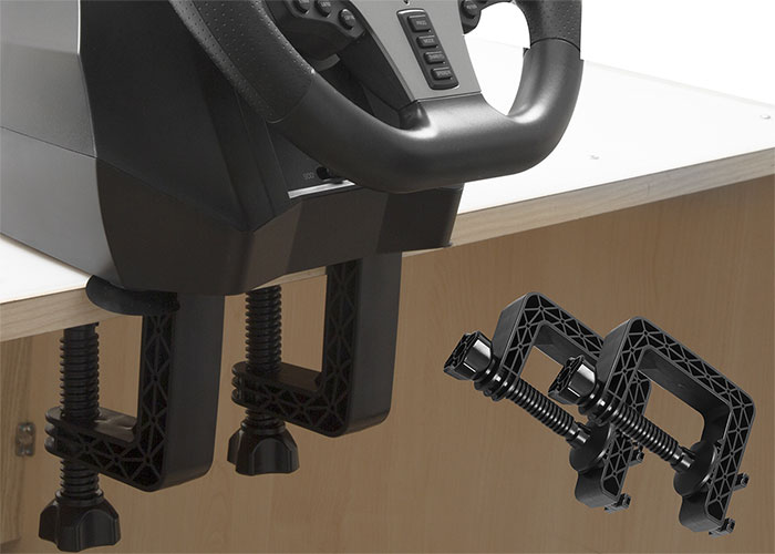 Bir oyun direksiyonu, kelepçelerle beyaz bir masaya monte edilmiştir.