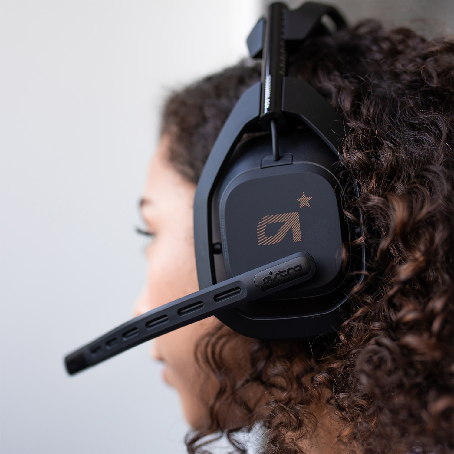 Person trägt schwarzes Astro Gaming-Headset. Logo mit A und Stern auf dem Ohrmuschel.