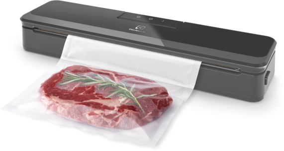 Egy vákuumlezáró gép egy steakkel és rozmaringgal egy zacskóban. A gép sötétszürke és elegáns.