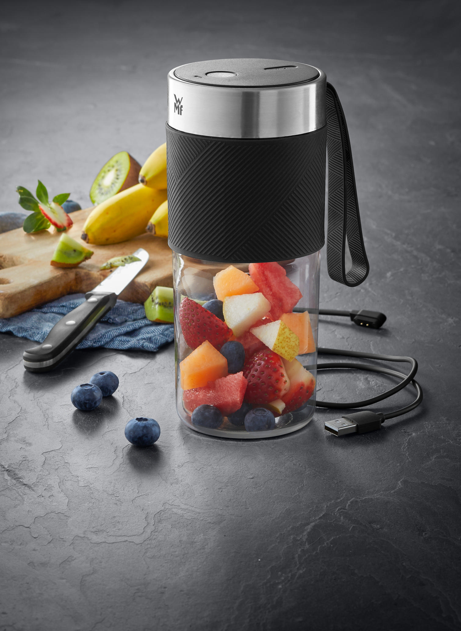 Mixer mit Früchten. Klares Glas mit Früchten, umgeben von schwarzem Sockel.
