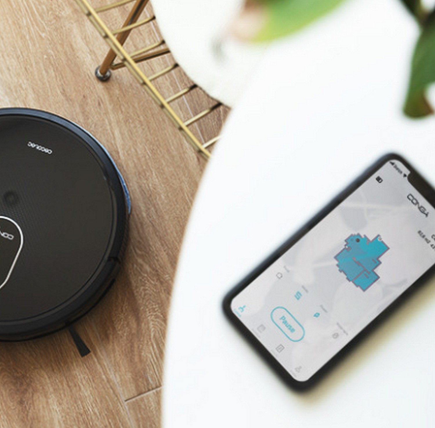 Aspiradora robot y un teléfono. El teléfono muestra un mapa.