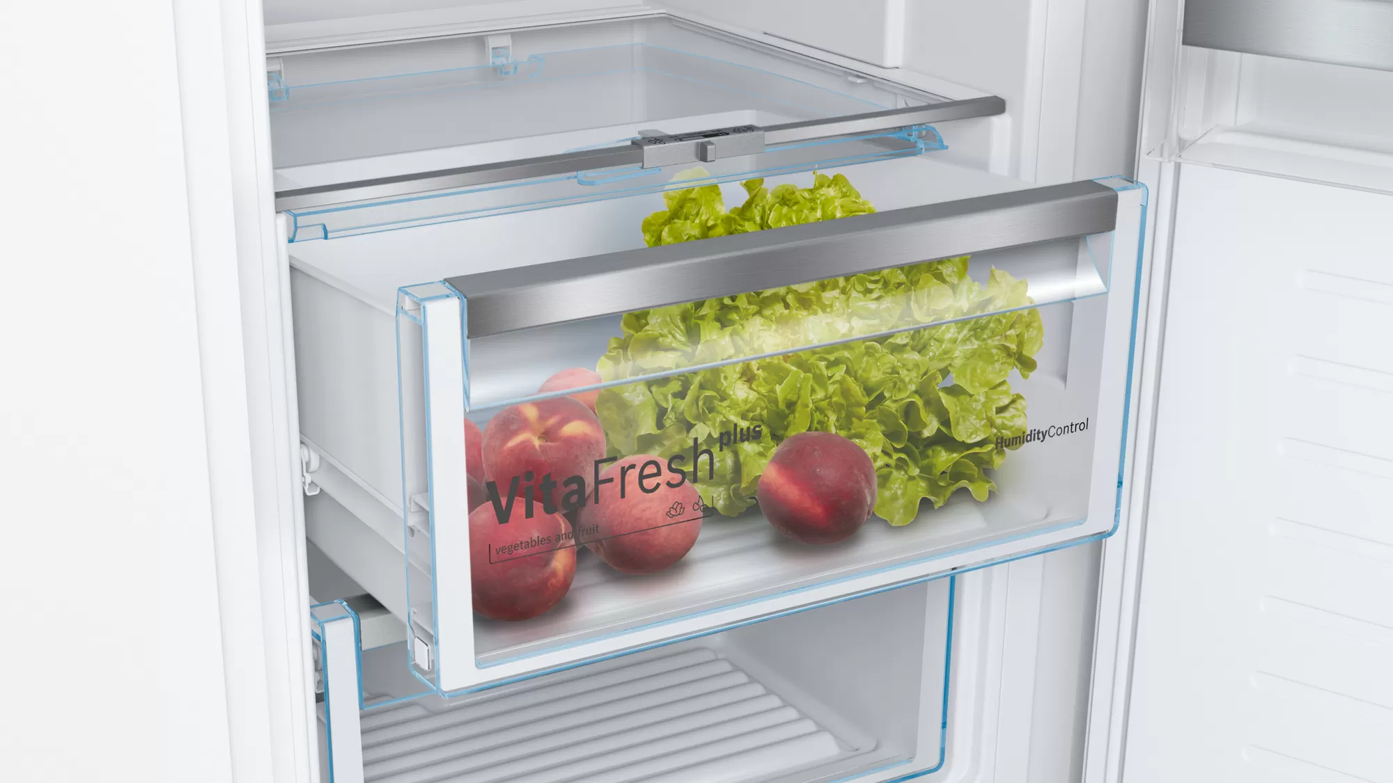 Tiroir de réfrigérateur avec pêches et laitue. Le tiroir indique 'VitaFresh plus'.