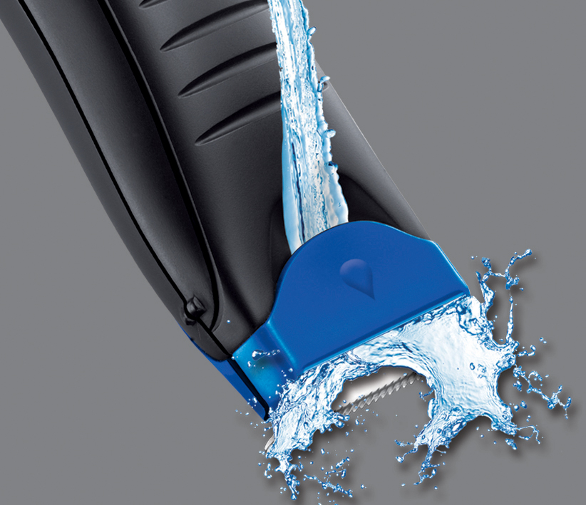 A water stream splashing onto the blue and black head of a shaver.