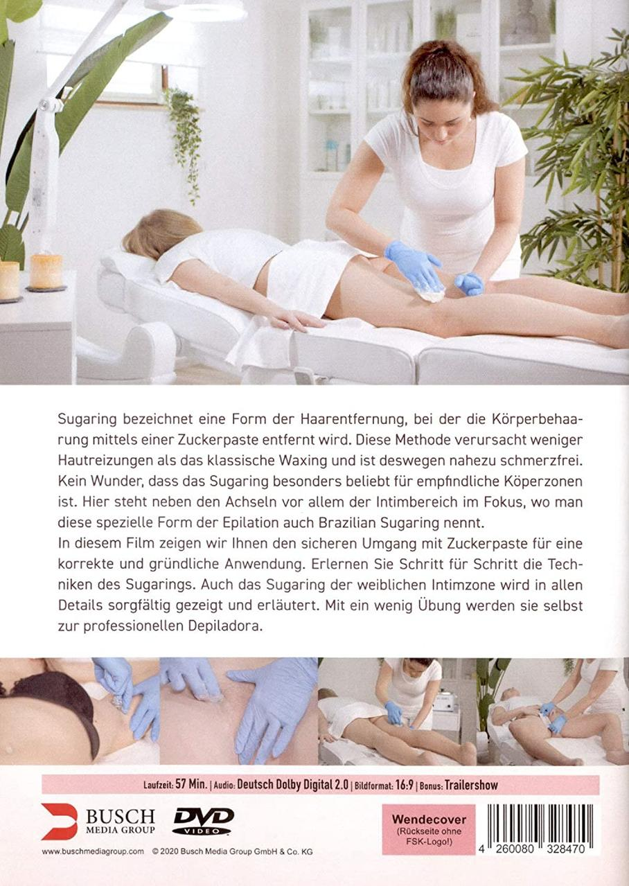 Eine Frau im weißen Hemd führt Sugaring an einem Bein einer anderen Frau durch. Text auf Deutsch.