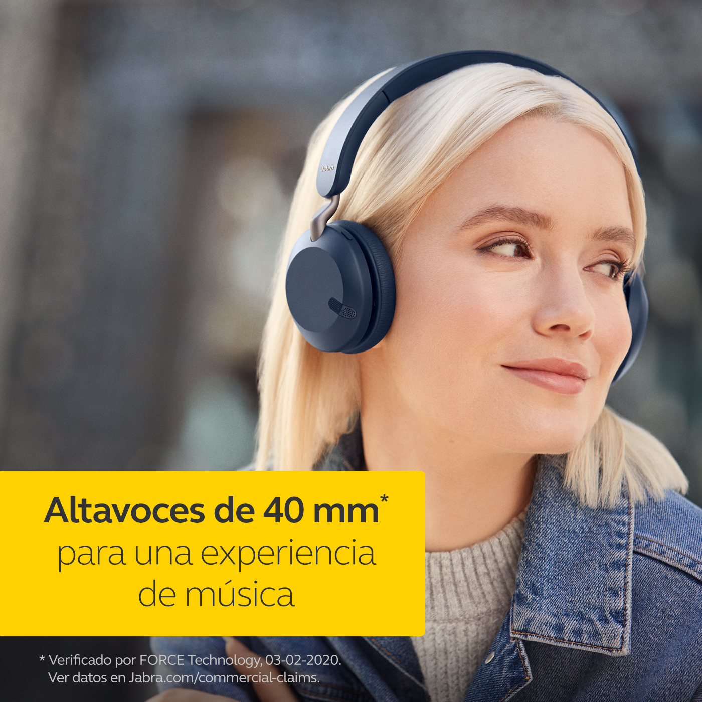 Una mujer con cabello rubio que usa auriculares azul oscuro, con texto en español sobre altavoces de 40 mm.